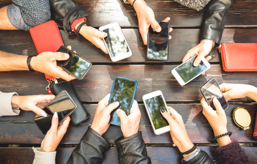 Hvordan dele internett fra mobilen uavhengig om du har Android eller iOS. Bilde viser hender som holder mobiltelefoner i ring.
